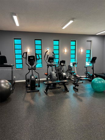 Indoor gym area with exercise equipment and windows.