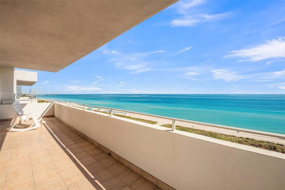 Balcony view overlooking the ocean with a beach below.