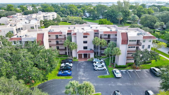 Front view of a multi-story apartment building with a parking area.