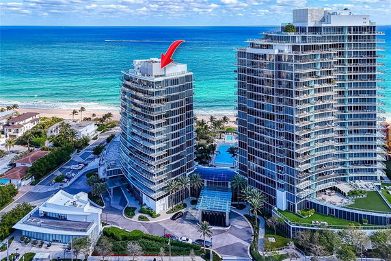Aerial view of two high-rise residential buildings near a beach.