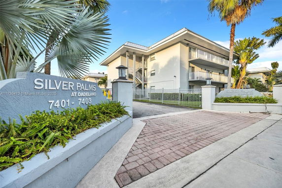 Front view of a multi-story residential building with balconies and gated entrance.