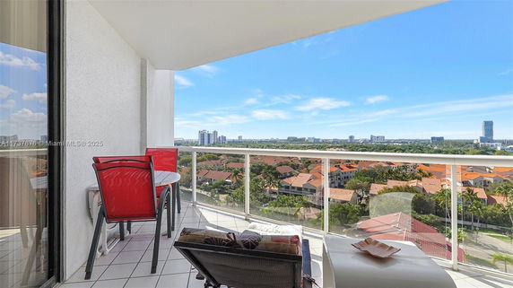 Balcony view overlooking residential area and cityscape in the distance.