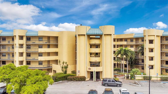 Front view of a multi-story building with balconies and a central entrance.