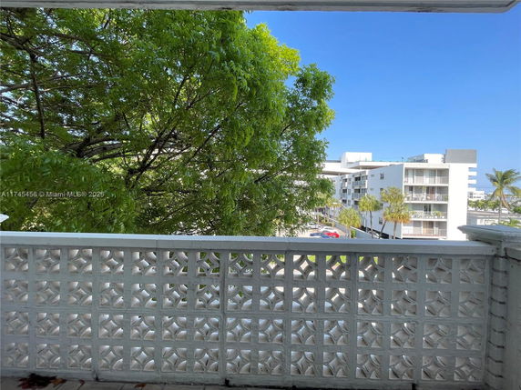 View from a balcony, showing nearby buildings and trees.