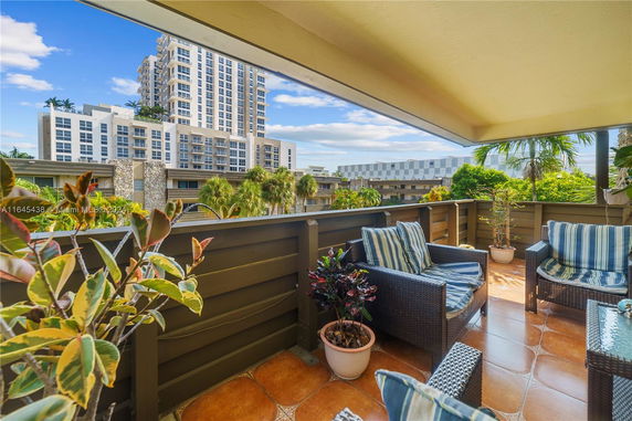 Balcony view with high-rise buildings in the background.