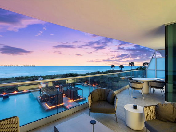 Panoramic view from a balcony overlooking the ocean at sunset.