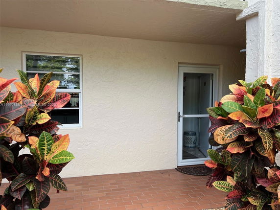 Front view of a house with a small patio and a glass door entrance.