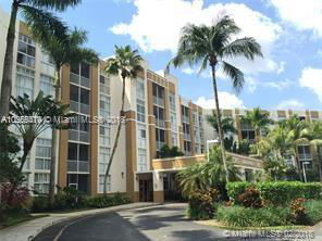 Front view of a multi-story apartment building with large windows and a covered entrance.