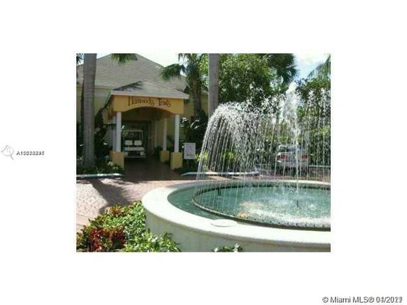 Entrance of a building with a fountain, featuring a covered entryway.