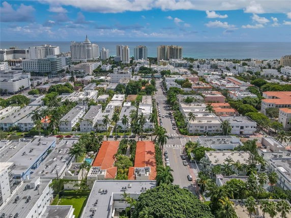 Aerial view of a city with ocean in the background, showing various buildings and streets.