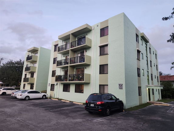 Front view of a multi-story apartment building with balconies.