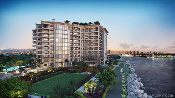 Front view of a multi-story luxury residential building with balconies, situated along a waterfront.