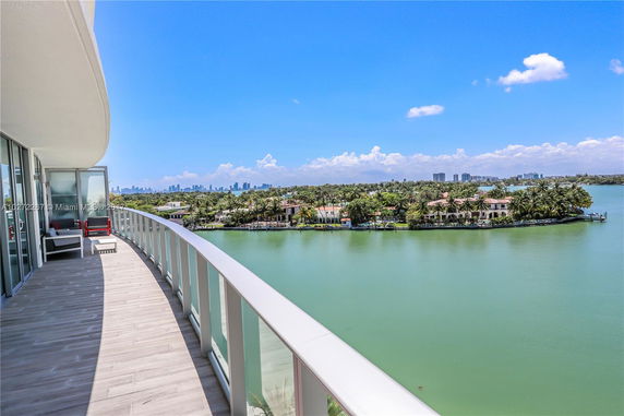 Balcony view overlooking water and distant city skyline.