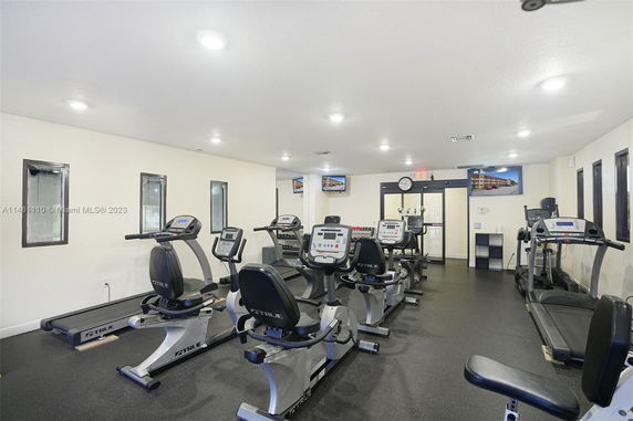 Interior view of a gym with exercise equipment including treadmills and stationary bikes.