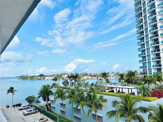 View of high-rise buildings and waterfront areas with palm trees.