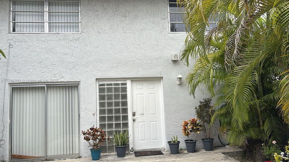Front view of a house with a white door and windows.
