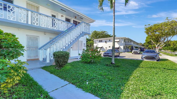 Front view of a two-story apartment building with external staircase.