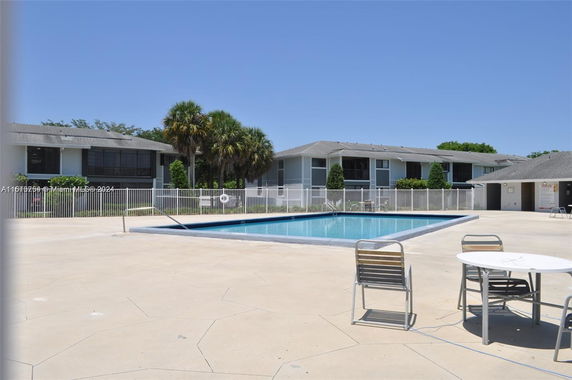 Outdoor swimming pool area with surrounding buildings.