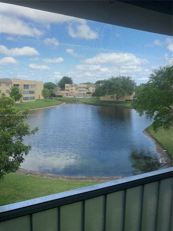 View of a lake with surrounding buildings and trees.