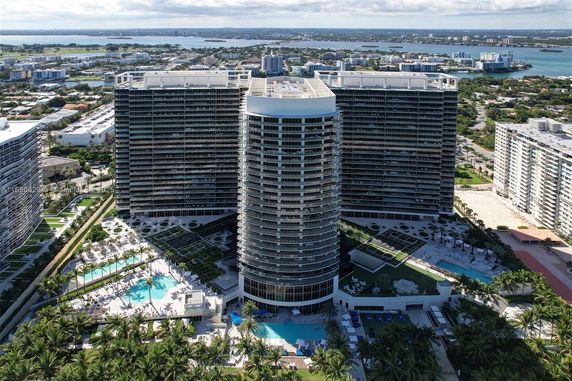 Aerial view of a large, modern high-rise building complex with surrounding urban and natural landscape.