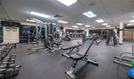 Indoor gym area with various exercise equipment including treadmills and weight machines.