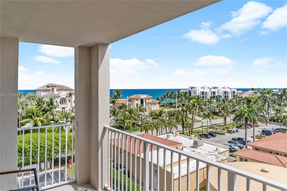 Balcony view showing coastal buildings and ocean in the background.