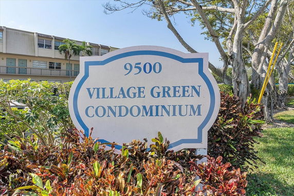 Front view of a condominium building with a sign in front.