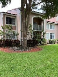 Front view of a two-story house with a balcony and arched entrance.