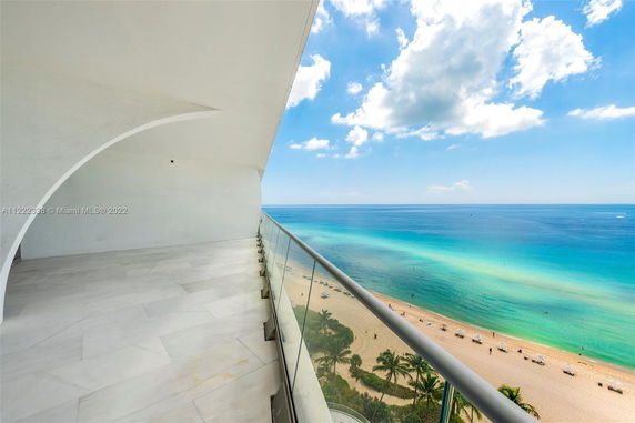 Outdoor balcony with panoramic view of the ocean and beach.