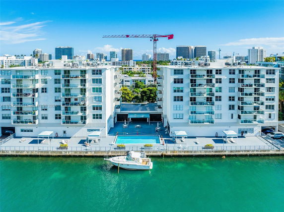 Front view of waterfront apartment buildings with balconies and a dock.