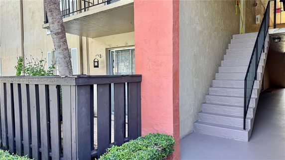 Exterior view of an apartment building with staircase and balcony.
