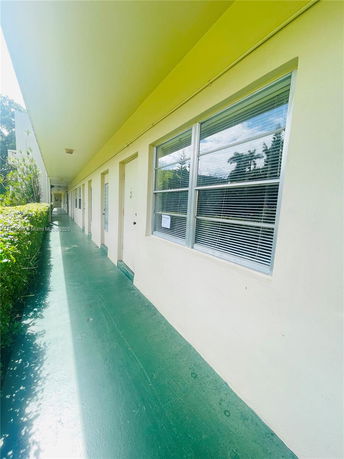 Exterior view of a building corridor with a row of doors and windows.