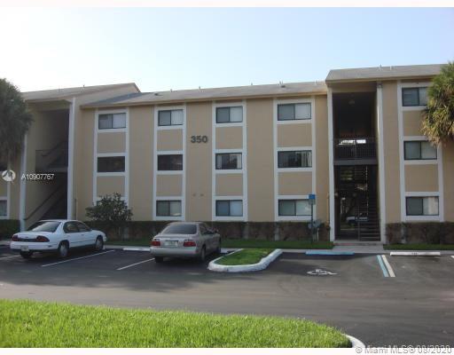 Front view of a multi-story apartment building with parking area.