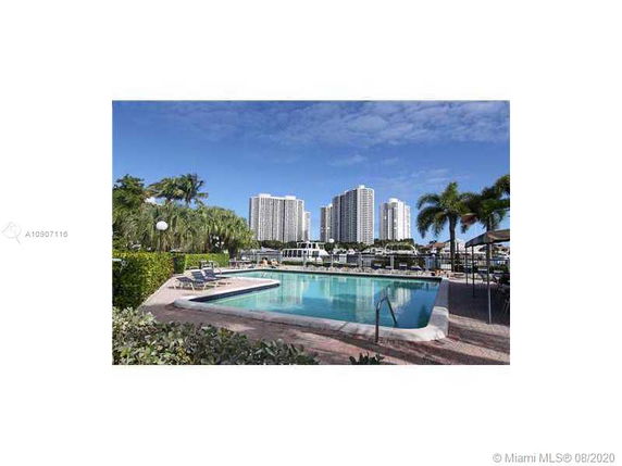 Outdoor swimming pool area with tall buildings in the background.