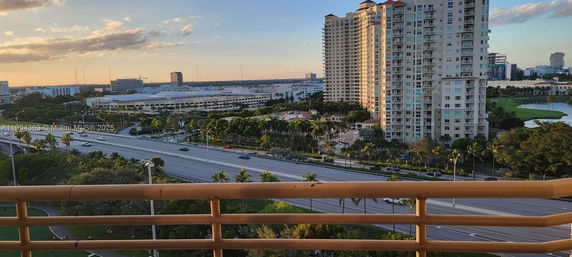 Panoramic view from a high vantage point showing a highway, tall buildings, and surrounding greenery.