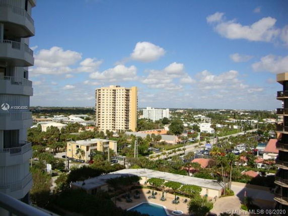 View of surrounding area with multiple buildings and a swimming pool visible from a high vantage point.
