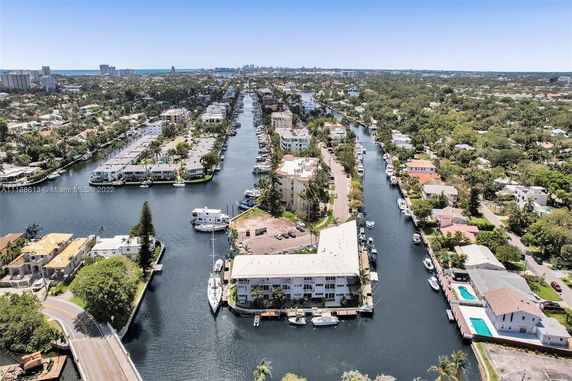 Aerial view of waterfront properties with canals and boats in a residential area.