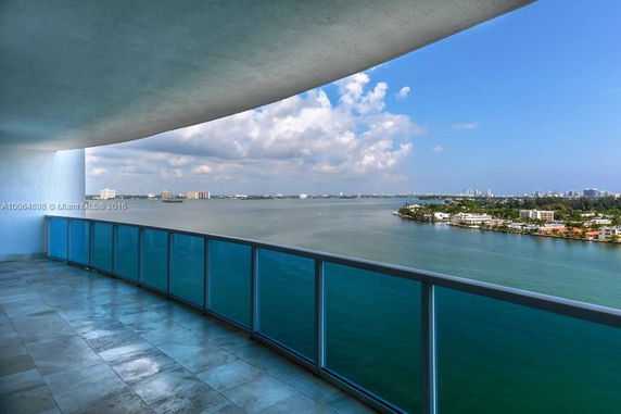 Panoramic view of a large body of water and cityscape from a building.