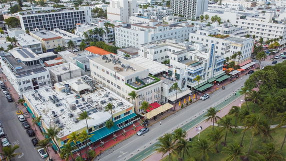 Aerial view of a cityscape with multiple buildings and palm-lined streets.