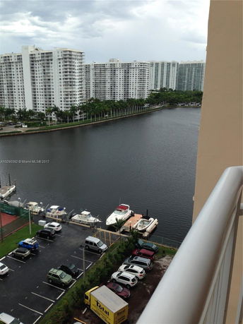 View from a building showing waterfront high-rise buildings and docked boats.