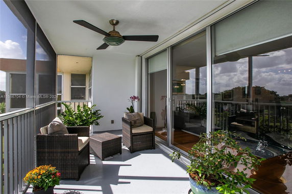 Balcony view with outdoor seating and sliding glass doors.