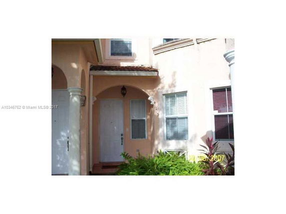 Front view of a house with an arched entryway and white door.