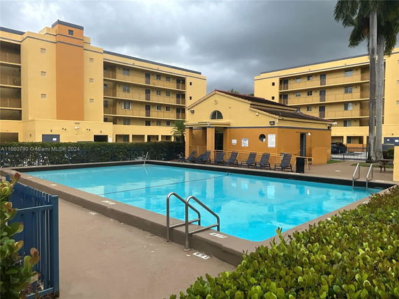 Outdoor swimming pool in front of an apartment building.
