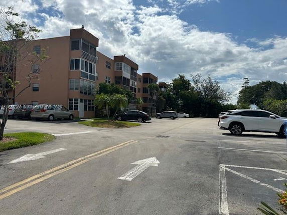 Parking area in front of a multi-story residential building.