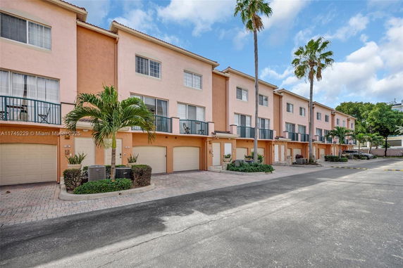 Front view of a multi-story townhouse complex with garages.
