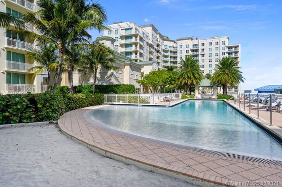 Swimming pool area in front of a multi-story residential building.