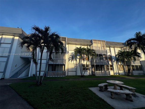 Front view of a multi-story building with balconies and exterior staircases.