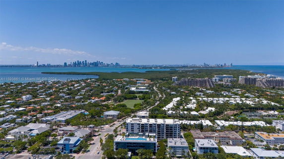 Aerial panoramic view of a coastal cityscape with city buildings, residential areas, and a body of water.