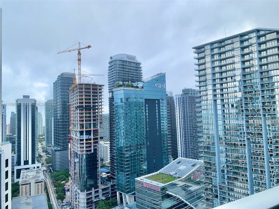 A cityscape featuring multiple high-rise buildings with a construction crane visible among them.