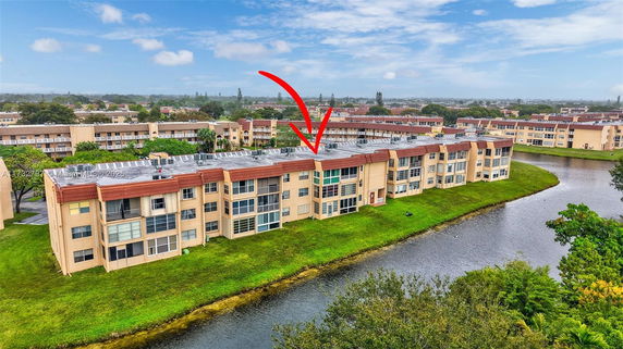 Aerial view of multiple residential buildings near a small water body.